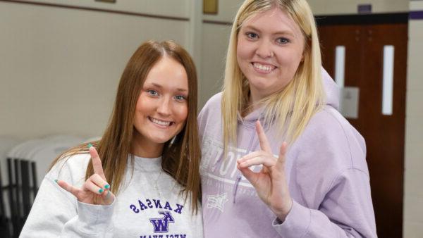 Female Students doing Yote Symbol